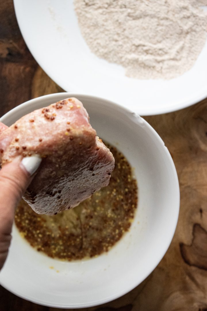 porkchops being dipped into a egg mixture