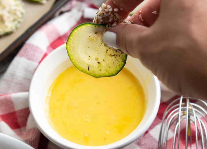 zucchini chip being dipped into egg