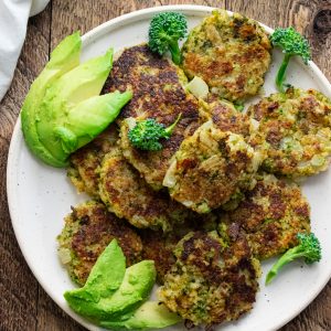 quinoa veggie patties on a white plate with broccoli and avocados