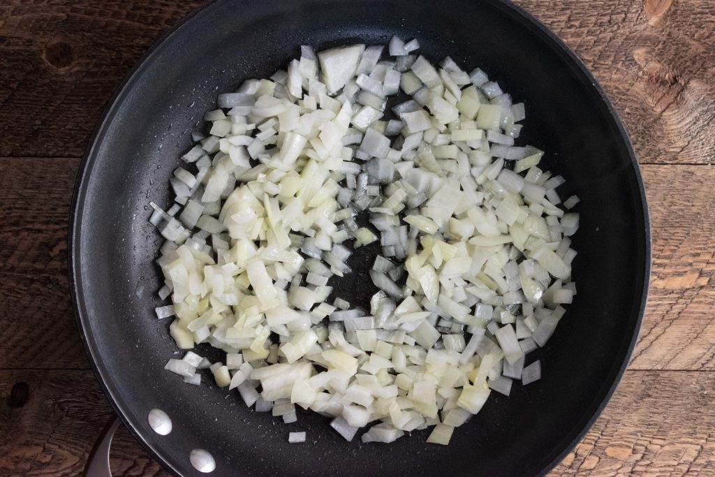 onion sauteing on a frying pan for quinoa veggie patties