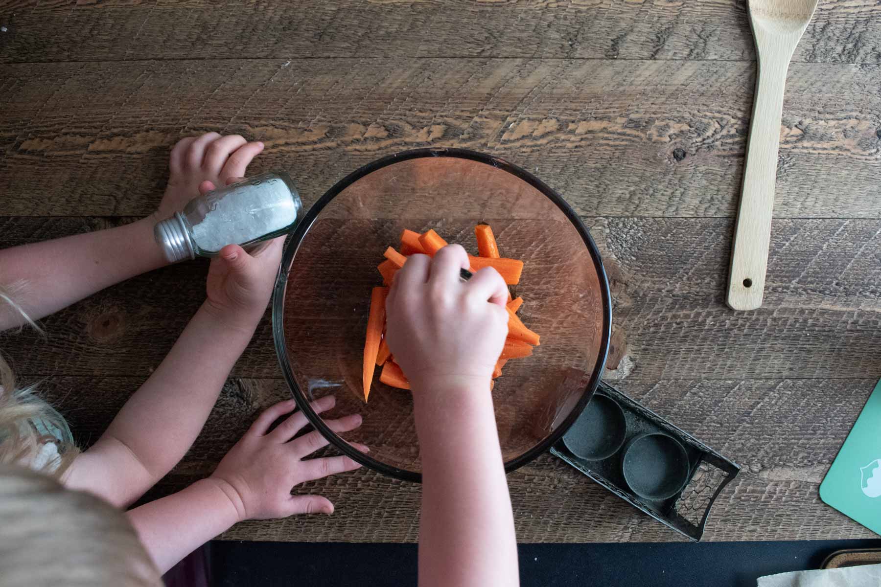 little kid hands helping to make the honey glazed carrots