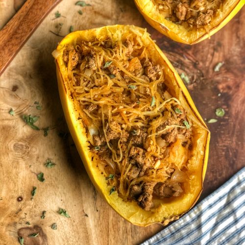 Spaghetti Squash Mexican Boats on a wooden board with a blue and white striped napkin