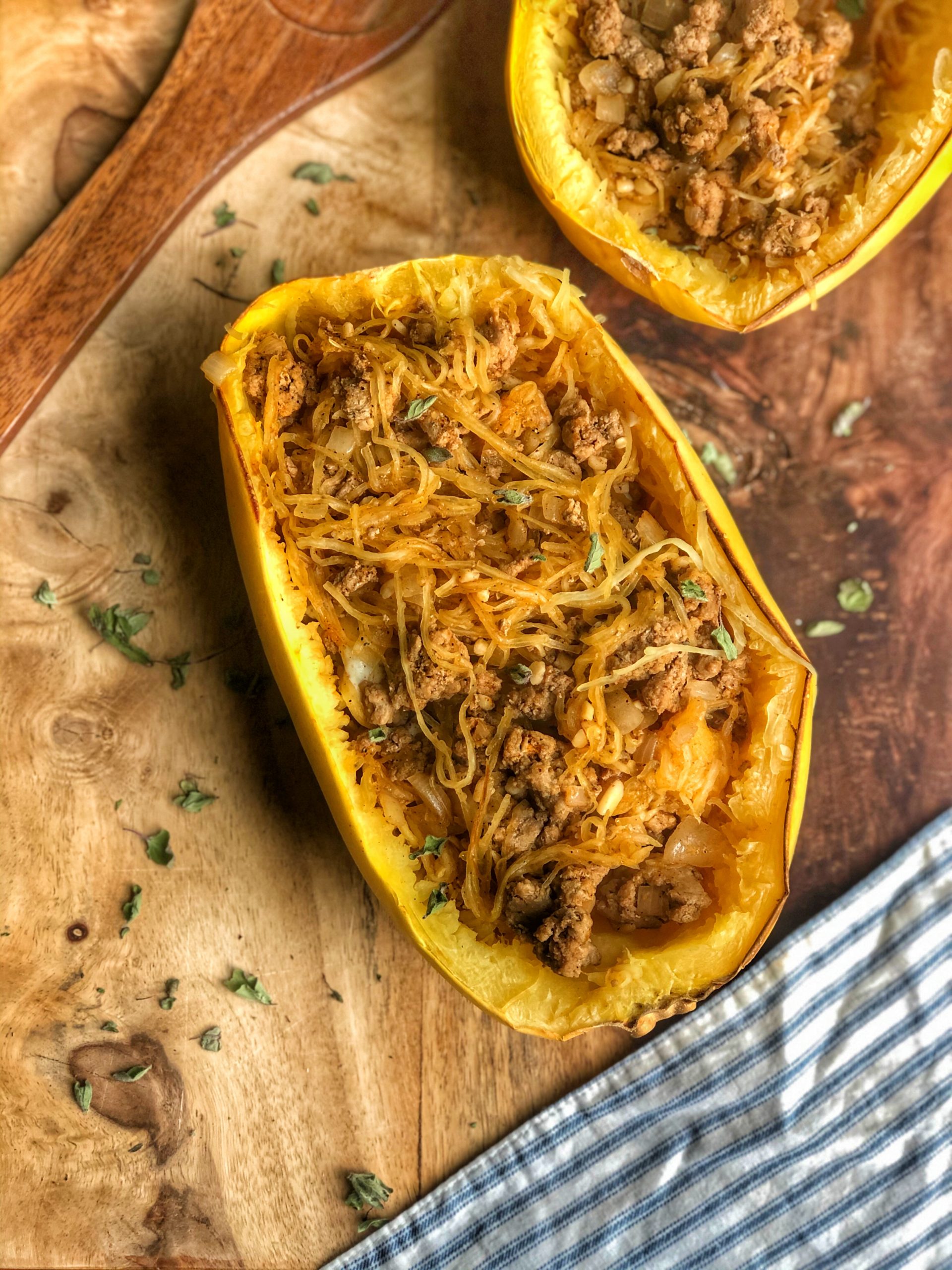 Spaghetti Squash Mexican Boats on a wooden board with a blue and white striped napkin