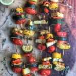 grilled veggie kabobs on a wooden board