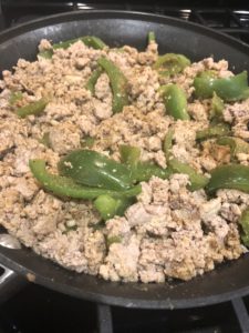 ground turkey and bell peppers cooking in a pan