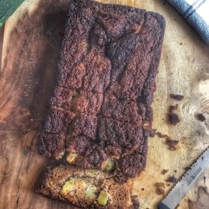 zucchini bread on a wooden board with a knife