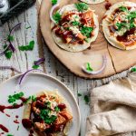 bbq chicken flatbread panera copycat version on a wooden board with bbq sauce sprinkled around