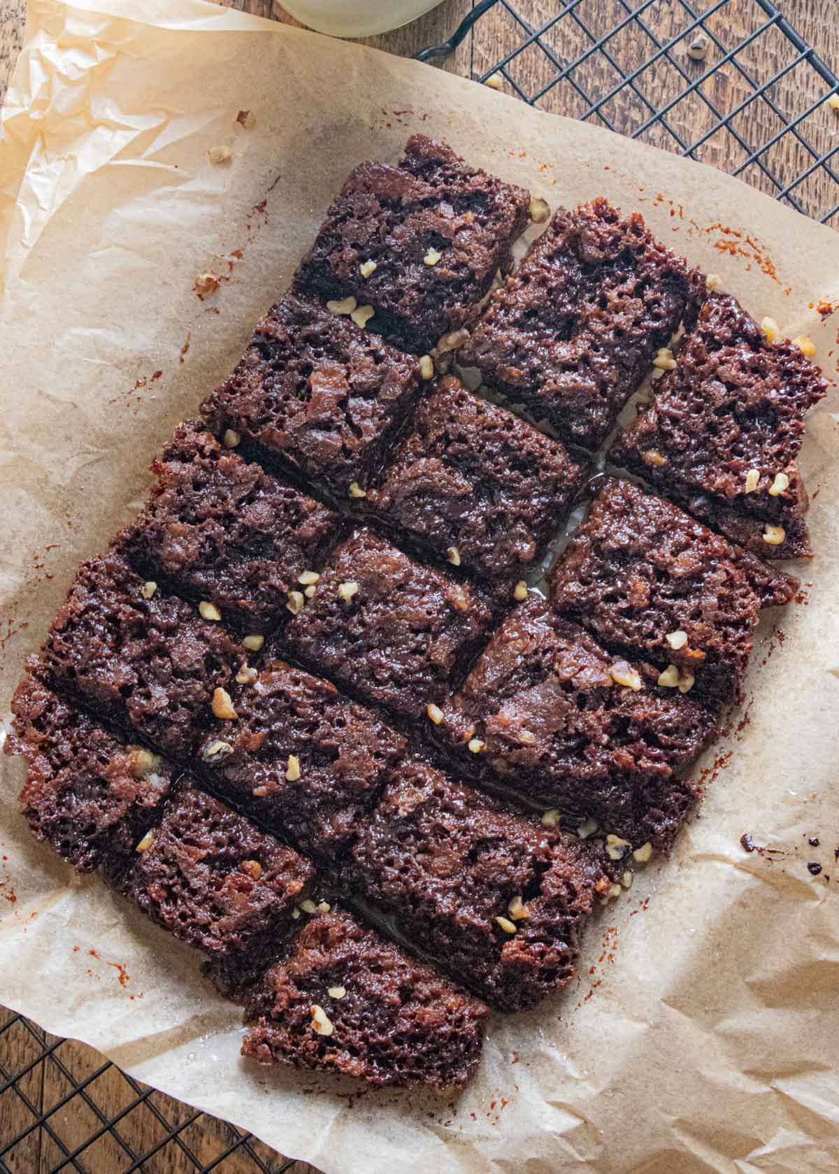 birds eye view of gluten free dairy free brownies on parchment paper on top of a wooden table