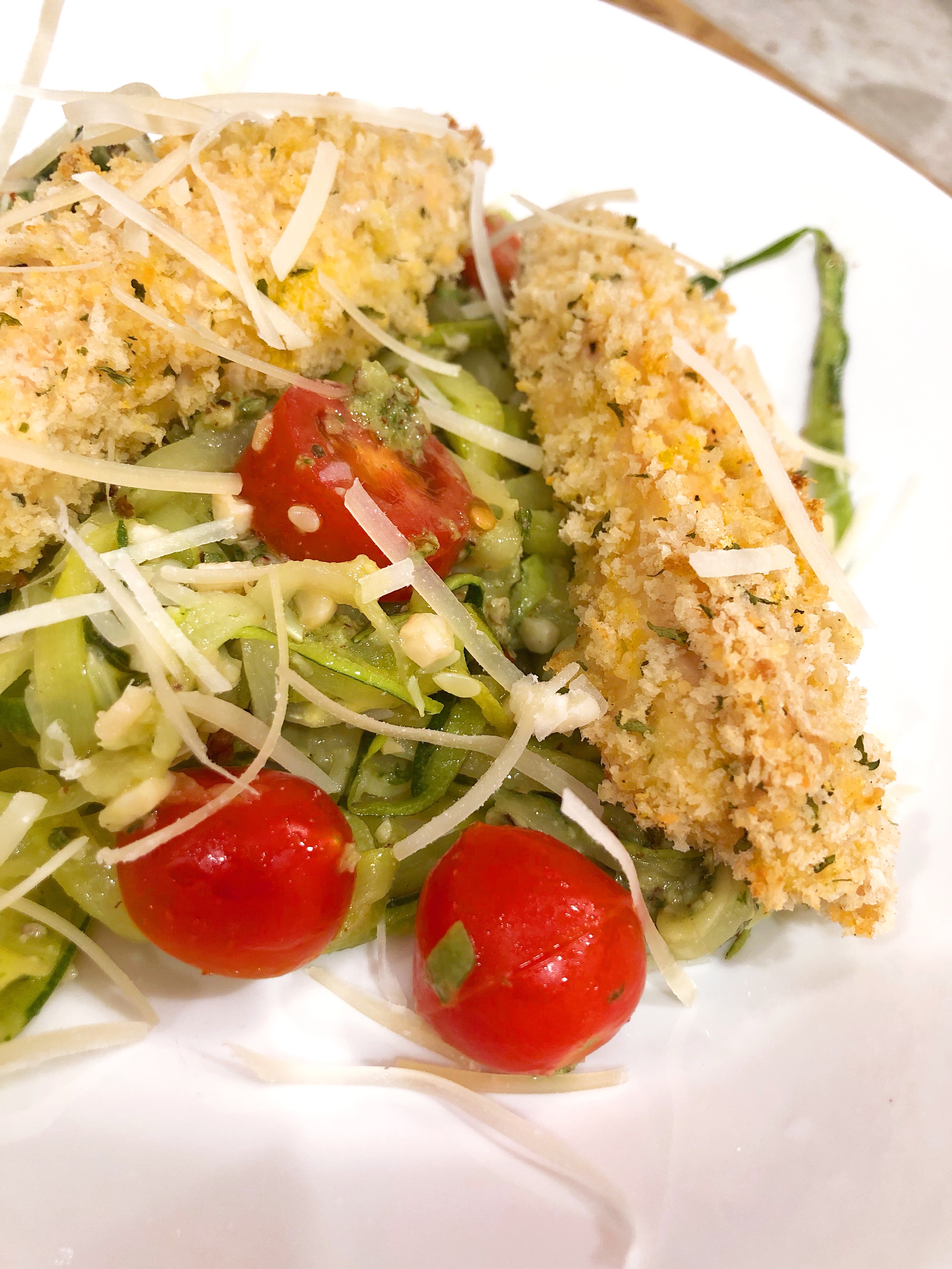 close up of panko chicken over zoodles with cherry tomatoes