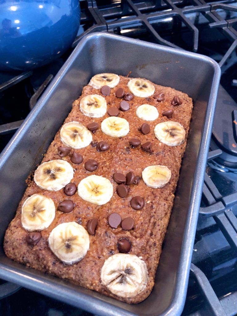 close up of flourless banana bread with chocolate chips and banana slices on top