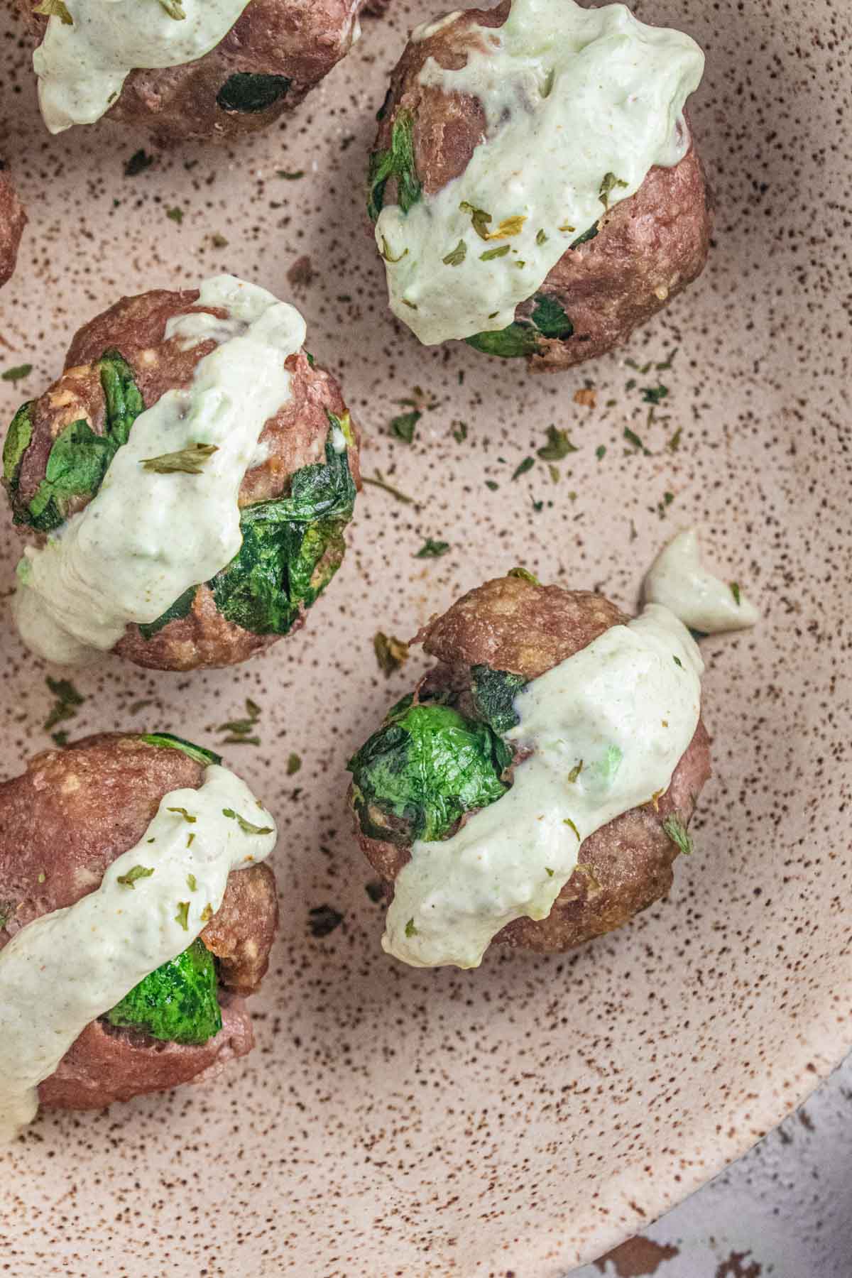 A close up of these delicious ground turkey meatballs drizzled with creamy avocado dip.