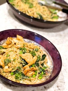 chicken carbonara in a bowl with peas and spinach