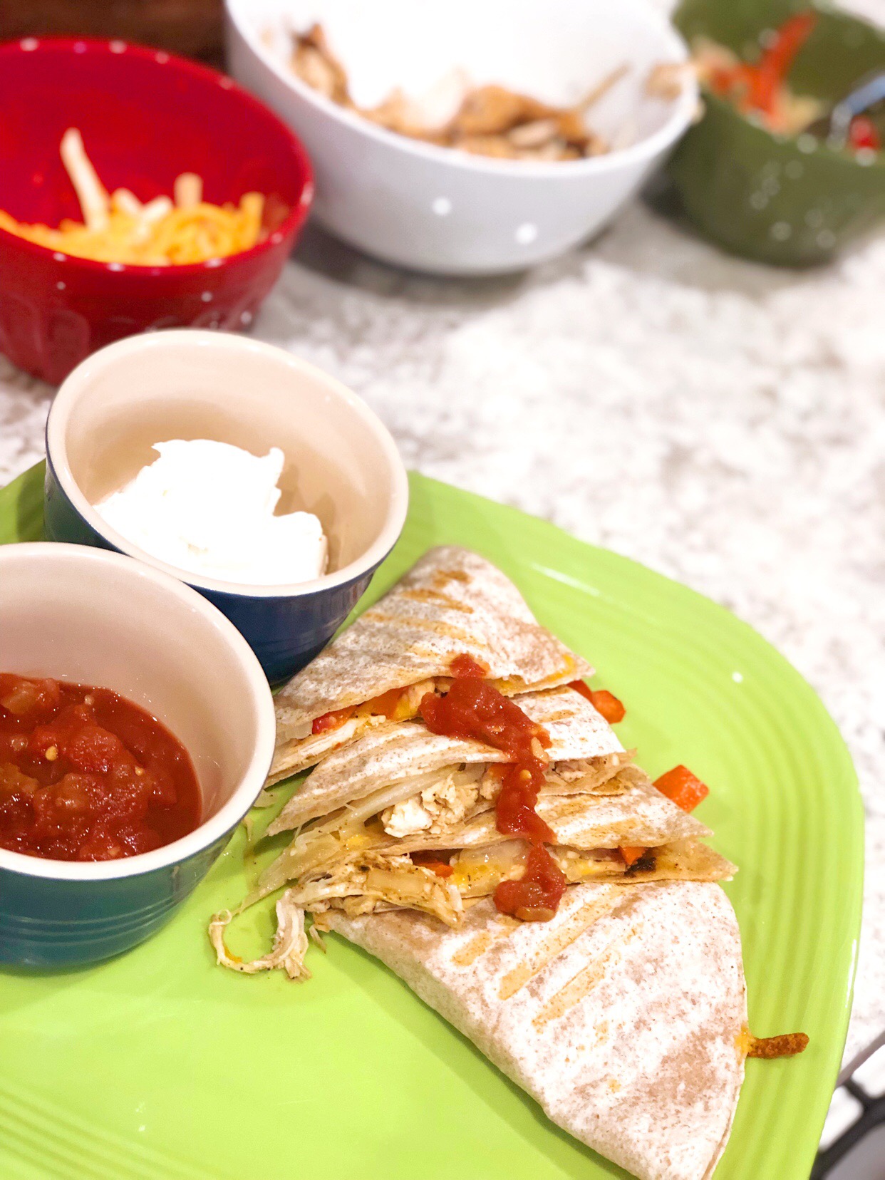 chicken fajitas on a green plate with plain greek yogurt and salsa on teh side