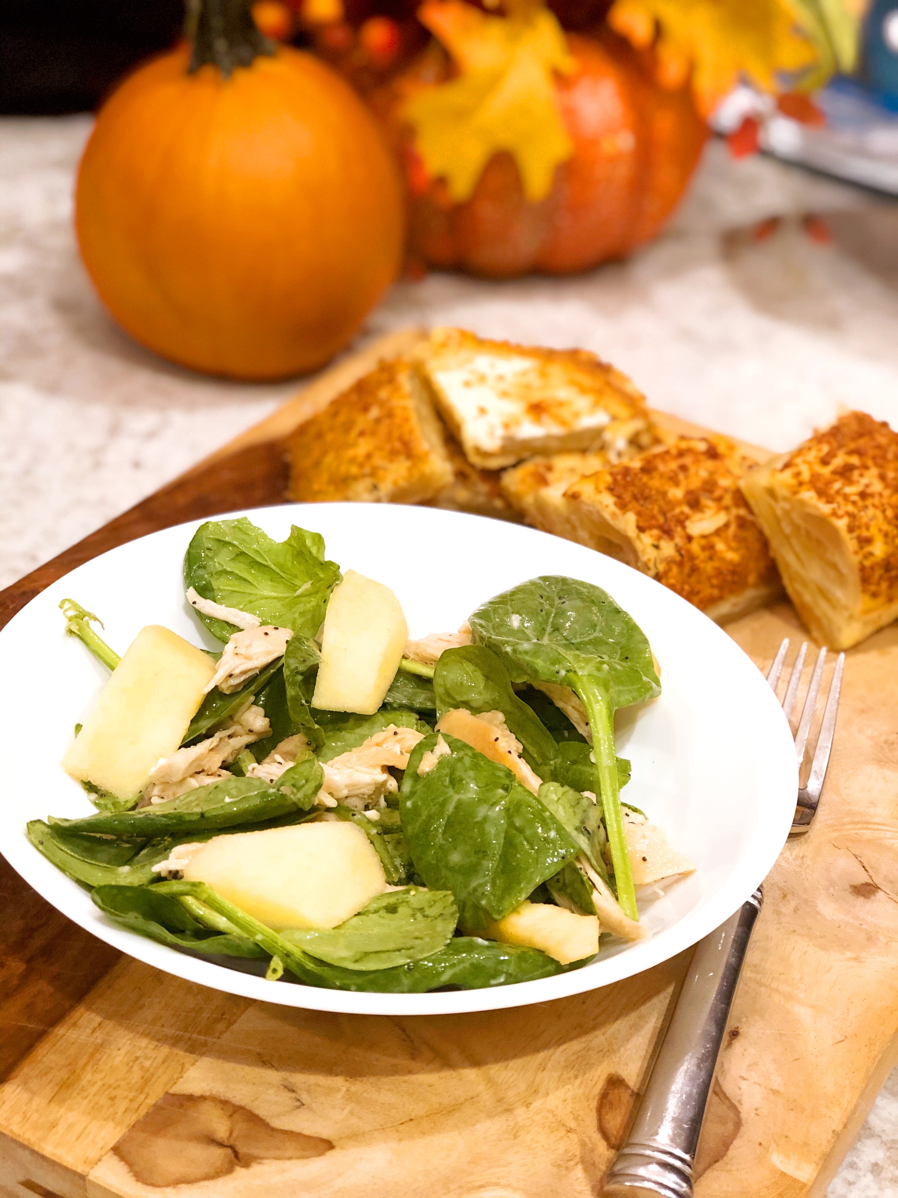 Chicken salad in a bowl with a cheese crisps on the side.