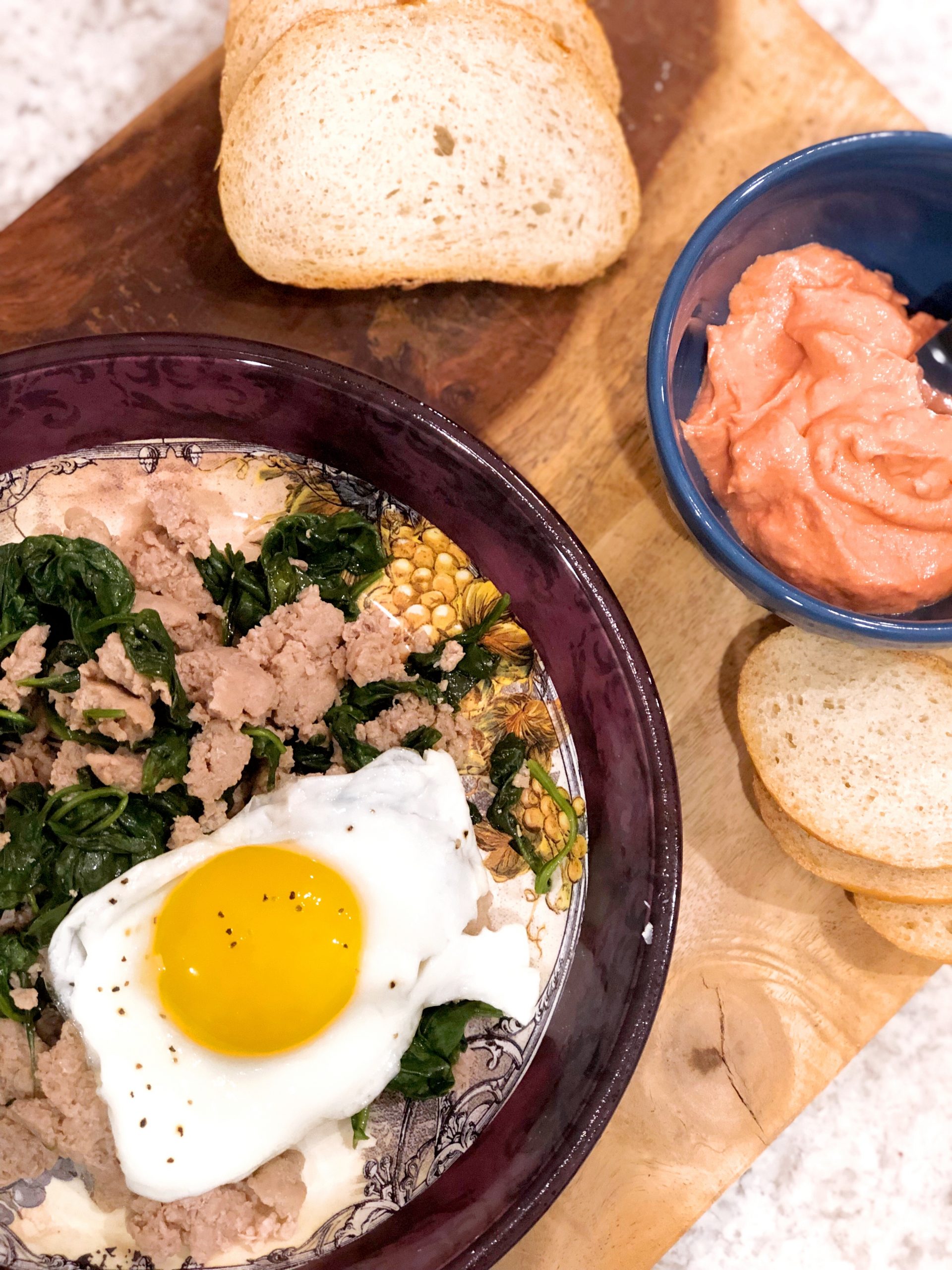 birds eye view of a fried egg over sausage and spinach