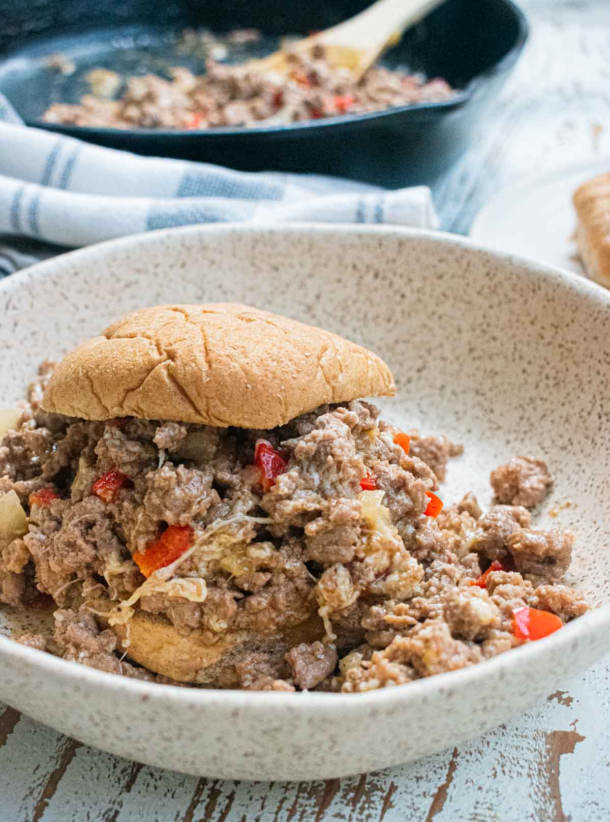 close up of a healthy sloppy joe in a white bowl on a white wooden table