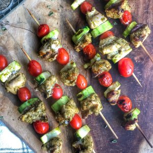 grilled chicken pesto skewers on a wooden board