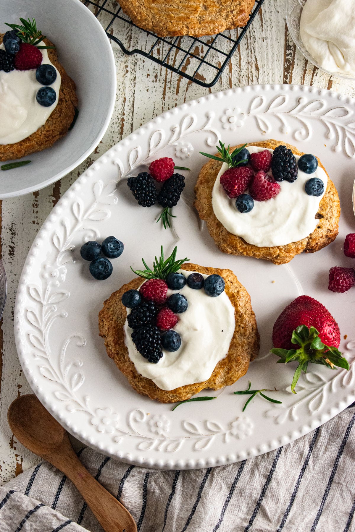 2 almond cookies topped with homemade whipped cream and fresh berries placed on top.
