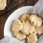 A close up of almond flour cookies on a white plate with a checkered napkin.