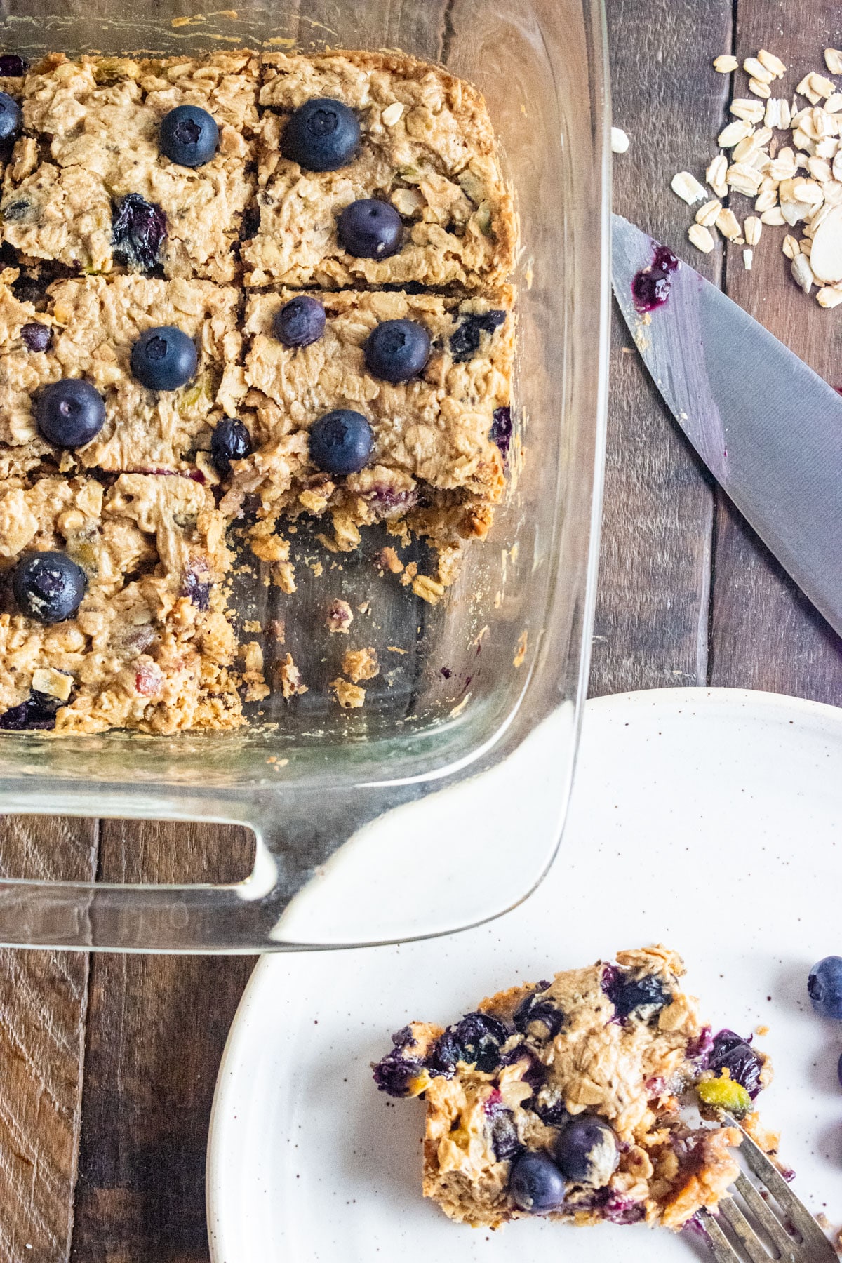 Birds-eye view of blueberry peanut butter bars and a piece cut out on a dish.