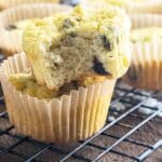 A close up of 2 coconut flour muffins sitting on top of one another on a cooling rack.