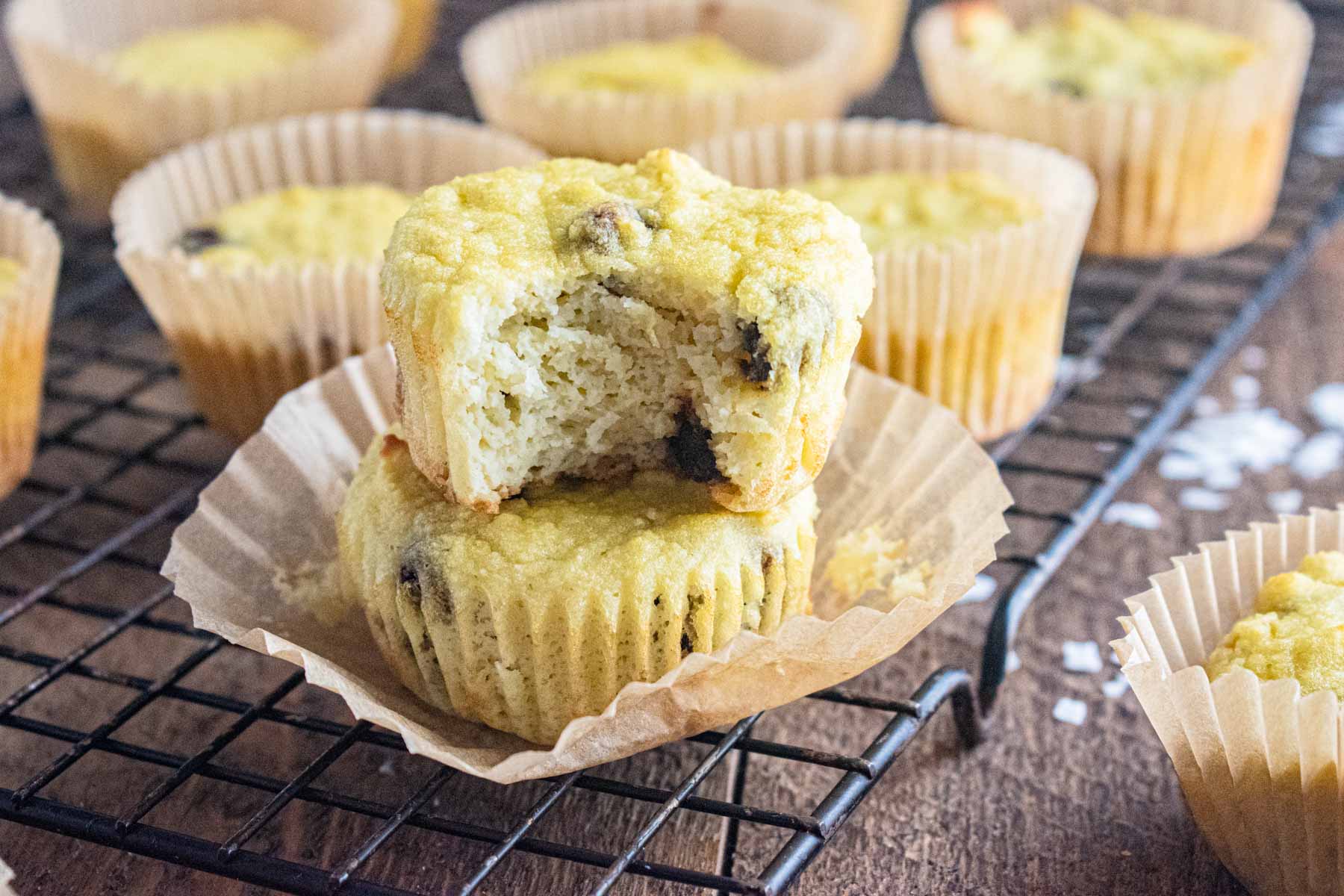 coconut flour muffins on a cooling rack stacked on top of one another.