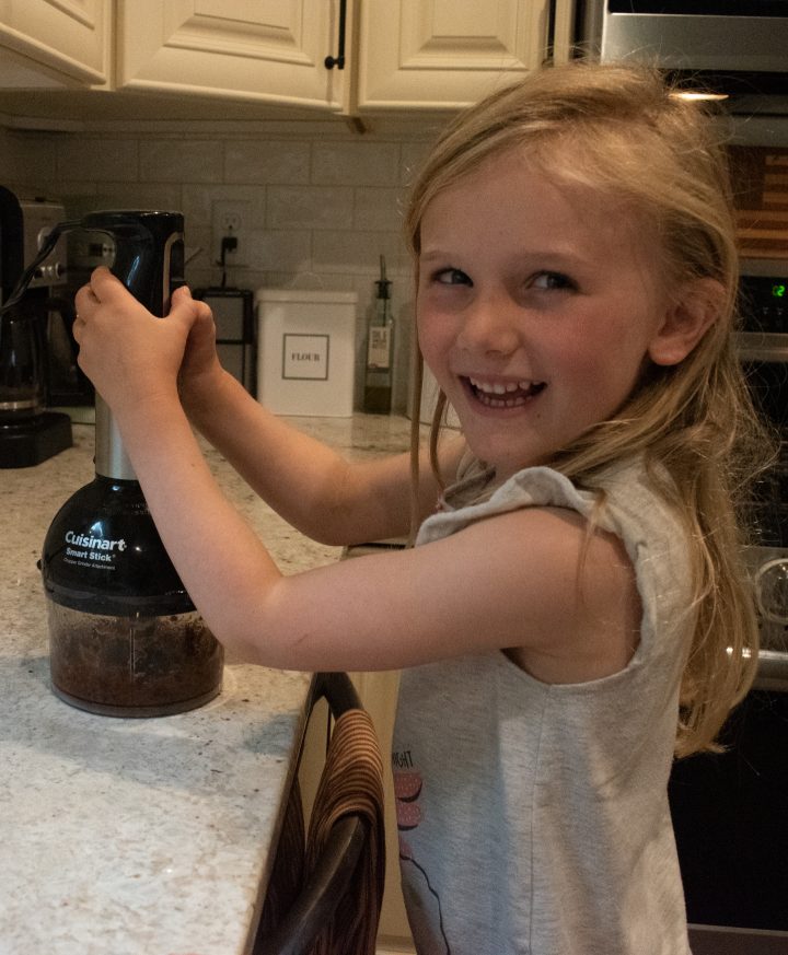 young child hand blending dates to make no bake energy bites