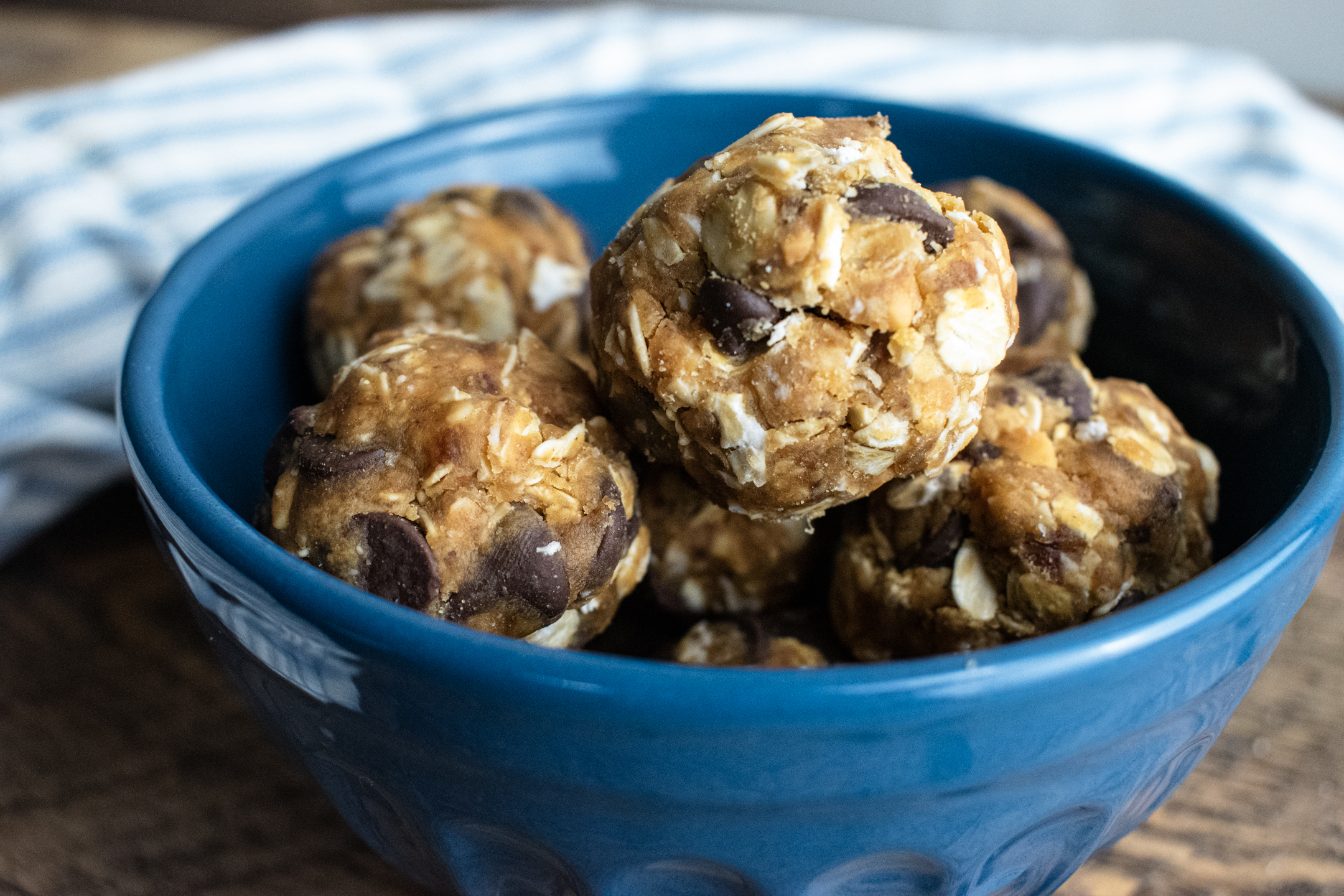 birds eye view of no bake energy bites in a blue bowl on a wooden table