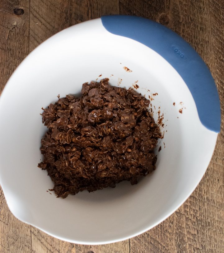 chocolate peanut butter balls mix in a mixing bowl on a wooden board