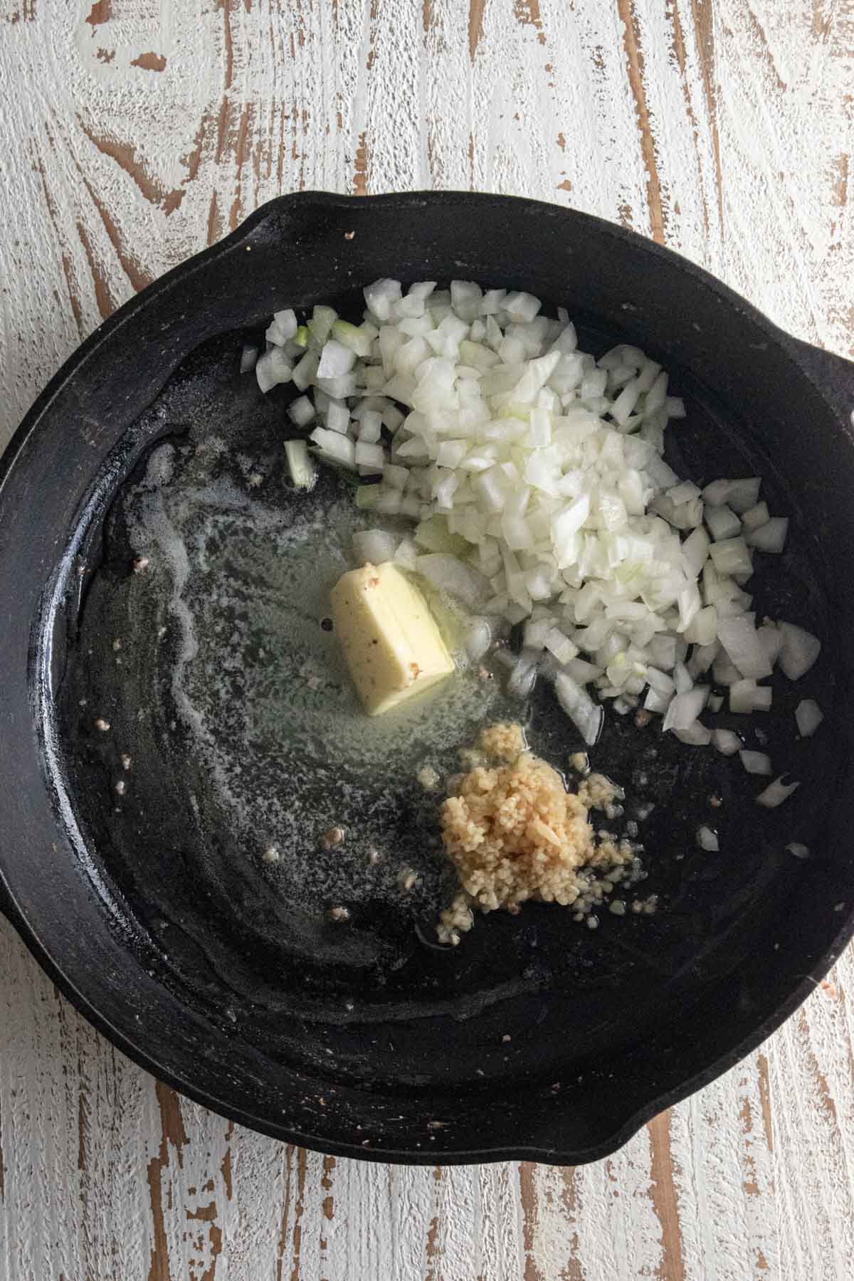 Step 3 - butter, onion, and garlic sauteing in a Lodge cast-iron skillet