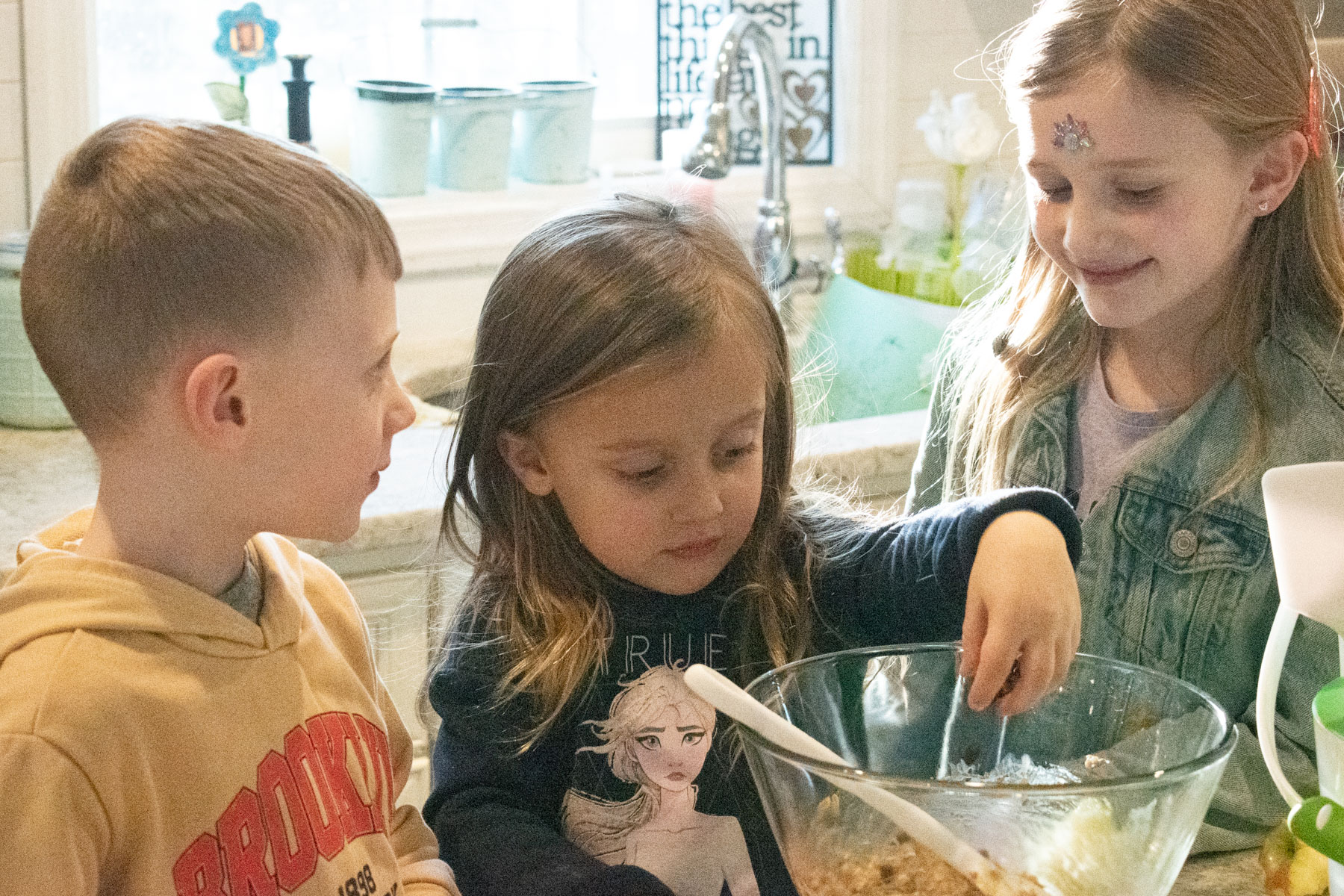 A picture of my three older kids helping mix the ingredients in this recipe. 