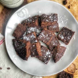 flourless fudgy brownies on a white plate