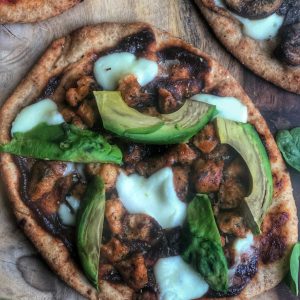 bbq chicken sausage and avocado pizza on a wooden board