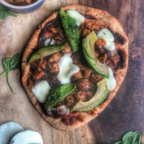 bbq chicken sausage and avocado naan pizza on a wooden board