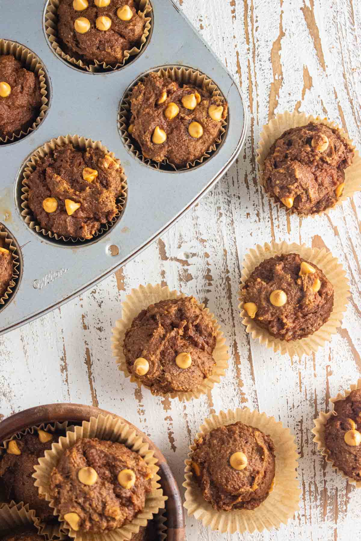 A birds-eye view of pumpkin butterscotch muffins on a white wooden table. 