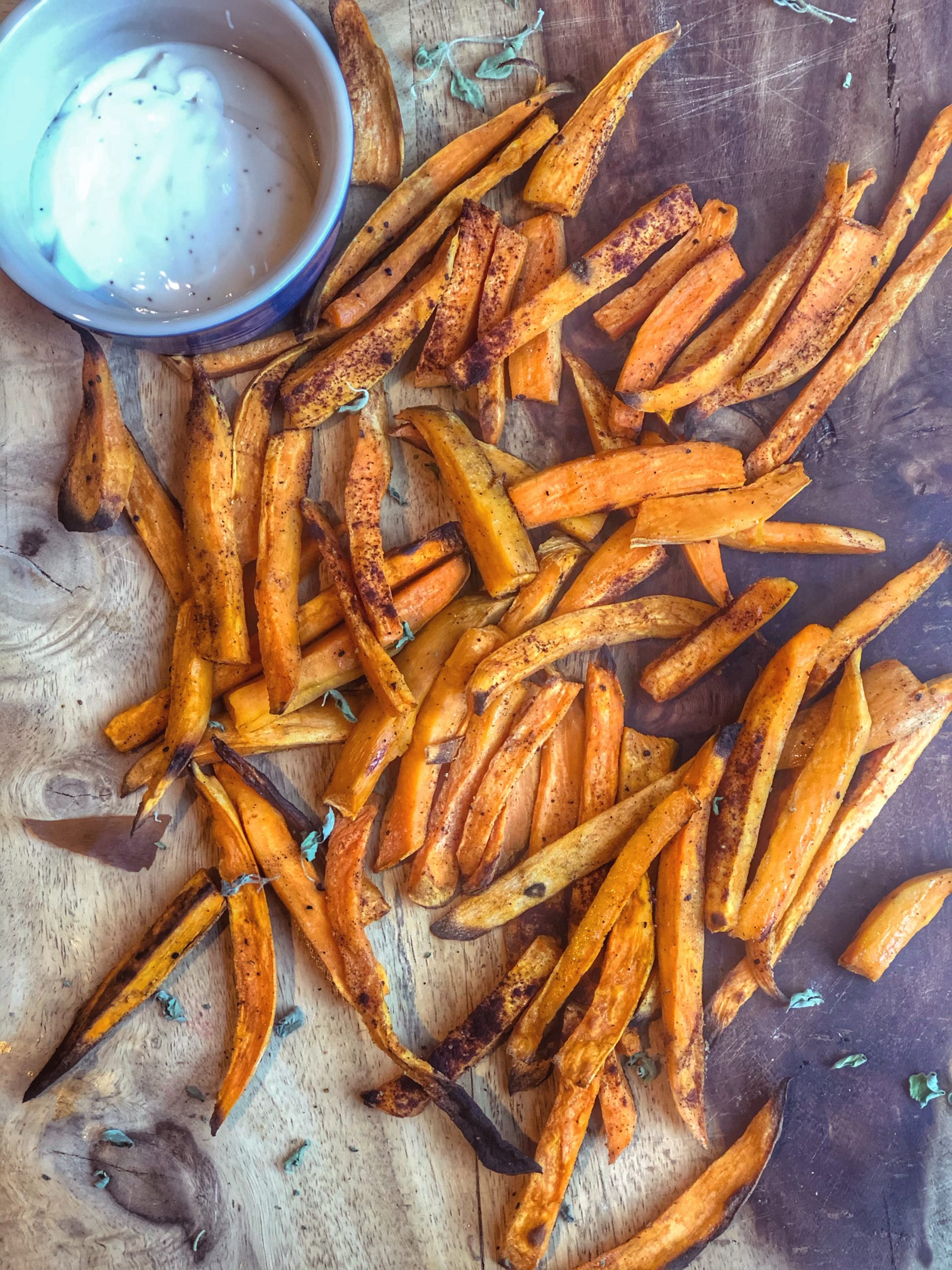 the crispiest sweet potato fries on a wooden board with ranch dressing