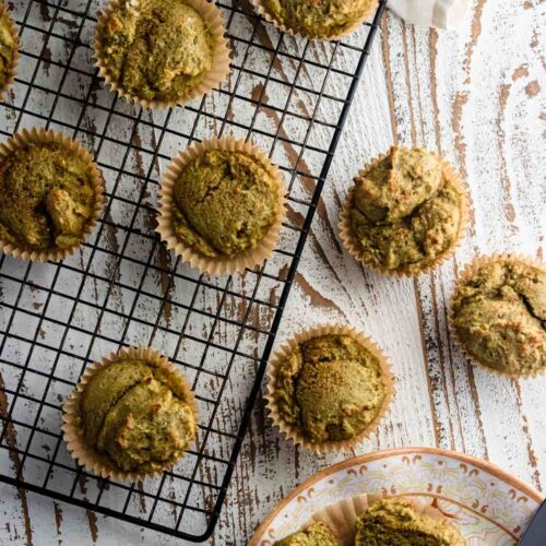 A birds-eye view of easy matcha muffins on a cooling rack on top of a white wooden table.