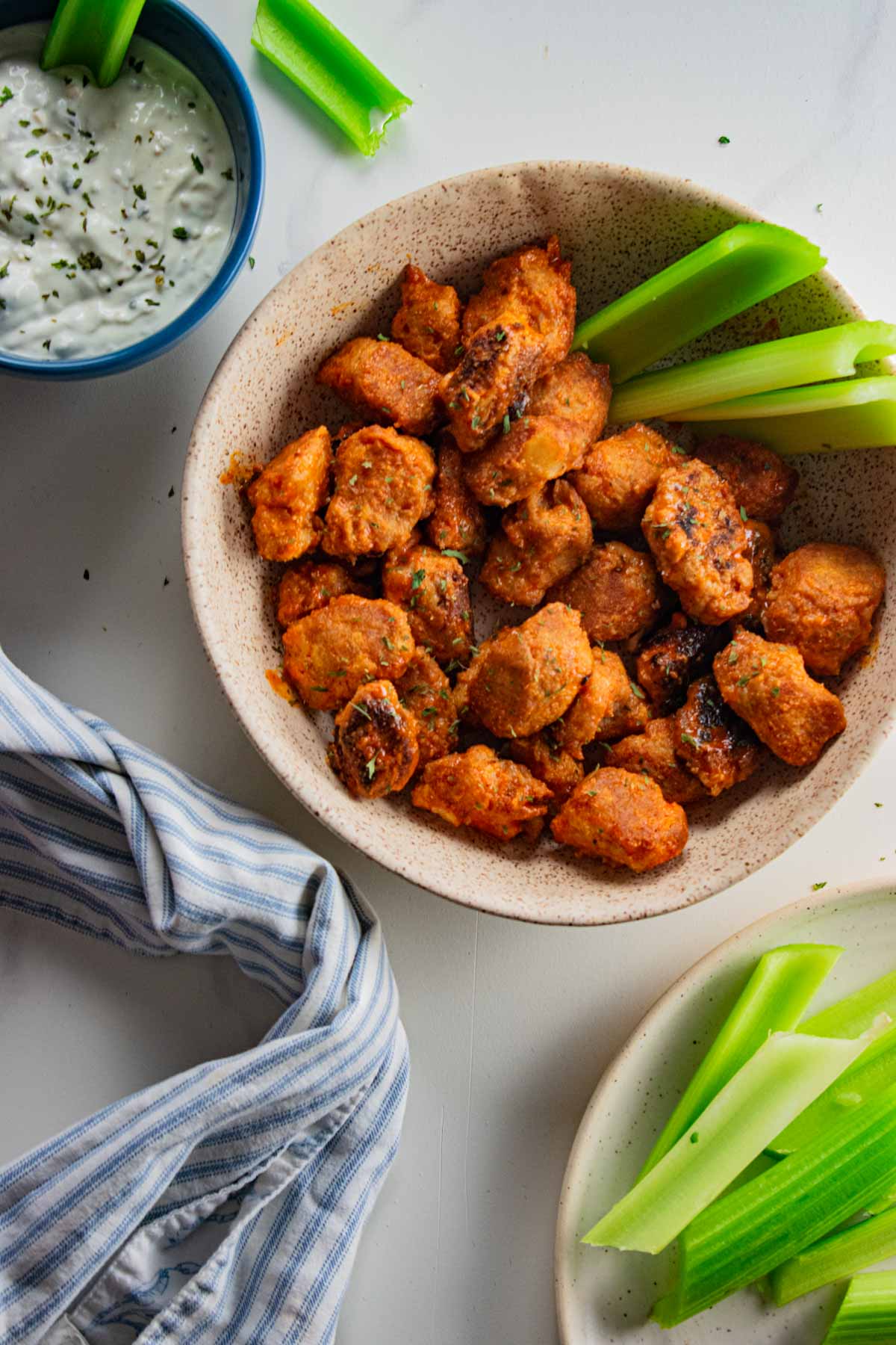 birds eye view of homemade buffalo cauliflower gnocchi with homemade blue cheese in a cream colored bowl