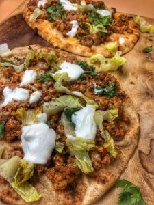 close up of taco naan pizza on a cutting board