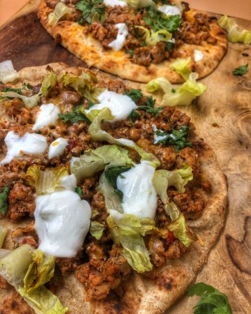 close up of taco naan pizza on a cutting board
