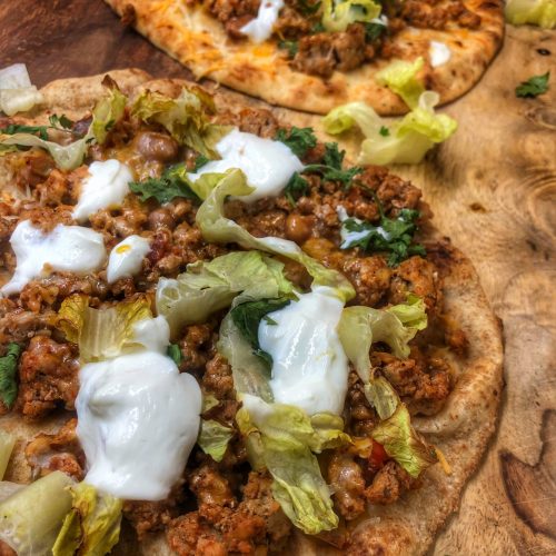 close up of taco naan pizza on a cutting board