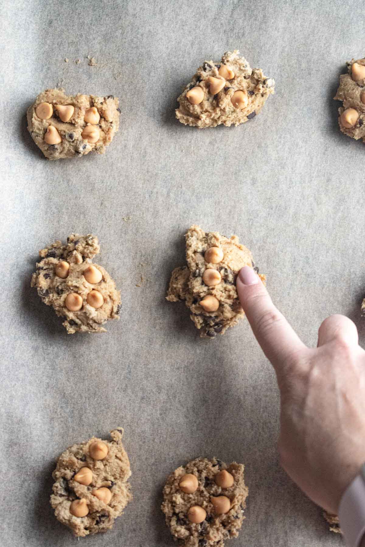 Step 8 - pressing butterscotch morsels onto the tops of your cookie dough mounds before being baked. 