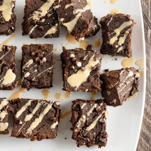Healthy fall pumpkin brownies on a white plate with butterscotch drizzled on top.