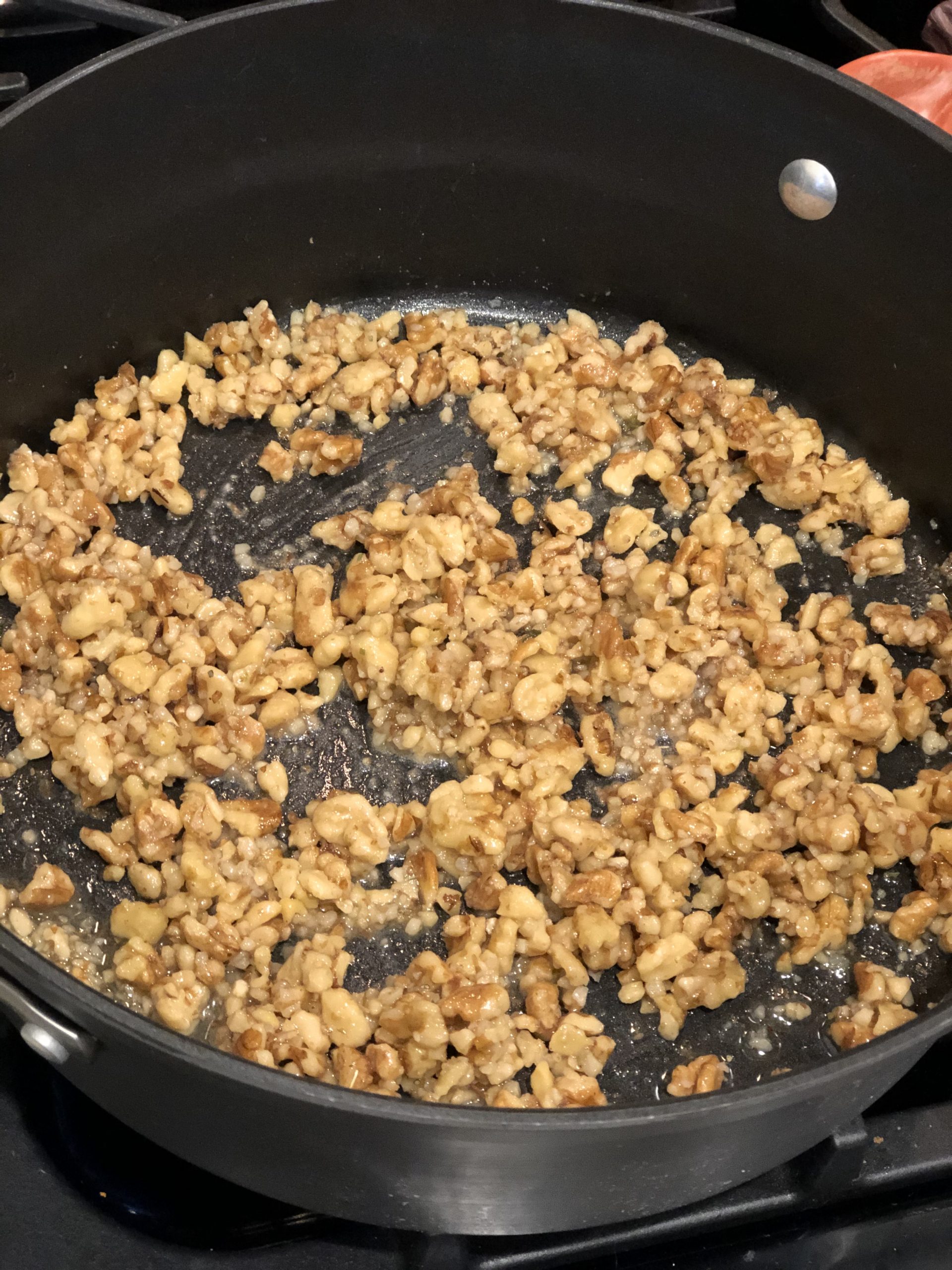walnuts being toasted on a large skillet