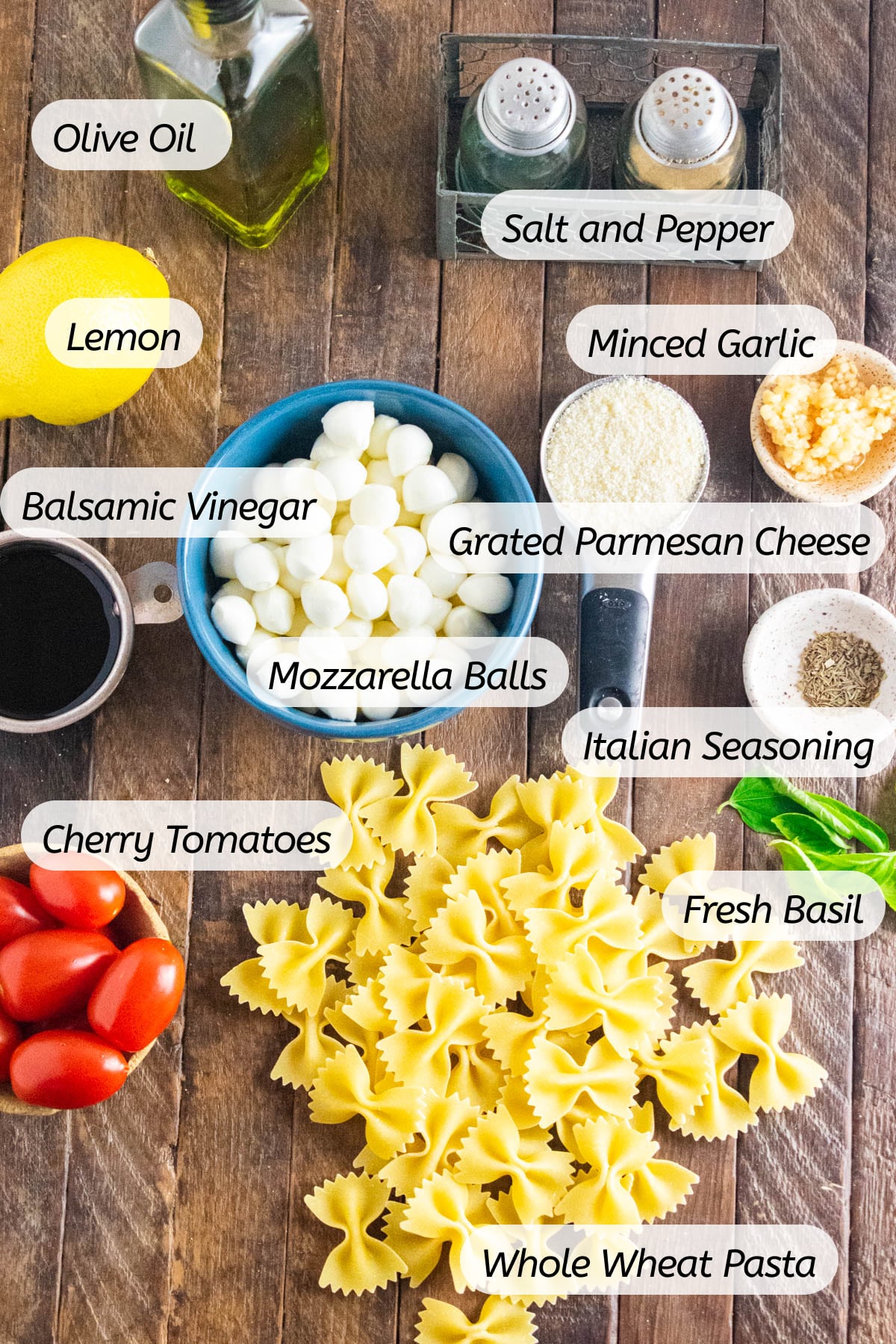 A photo of all the ingredients needed to make this caprese pasta salad with labels included.