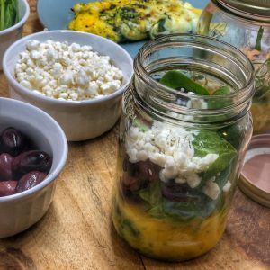 greek omelette breakfast jar on a wooden cutting board