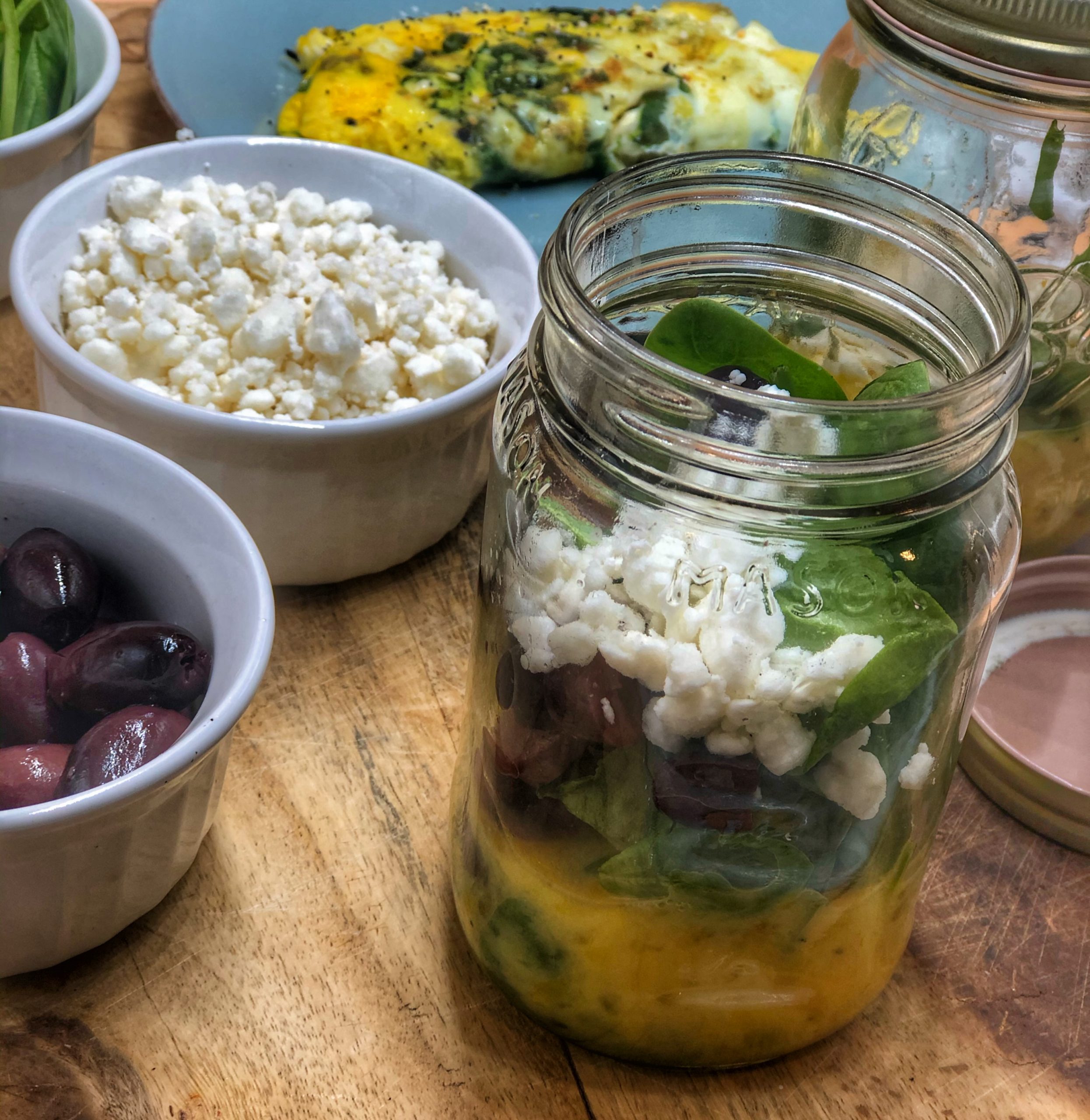 greek omelette breakfast jar on a wooden cutting board