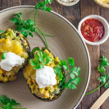 Birds eye view of 2 stuffed avocado tacos on a cream colored dish.