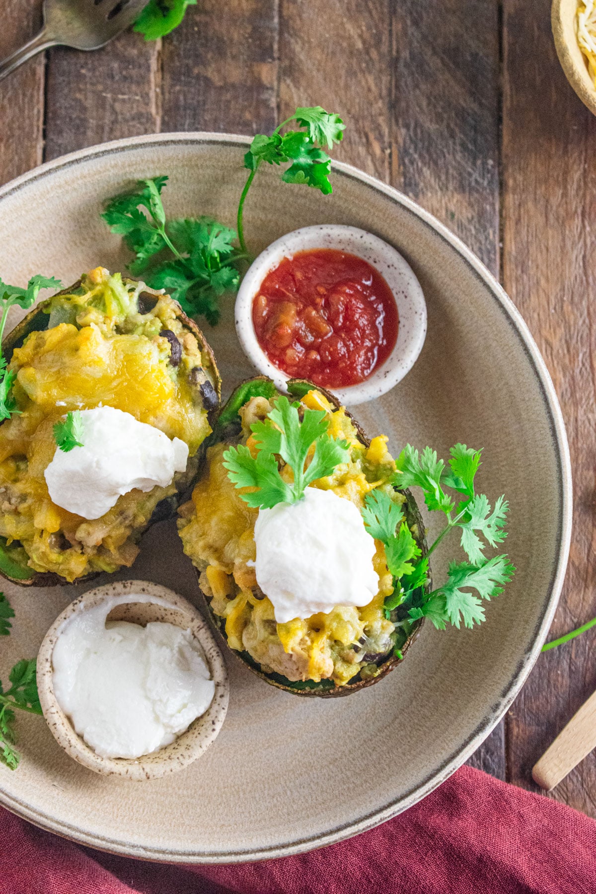 Two stuffed avocados with ground chicken, cheese, salsa, and plain greek yogurt.