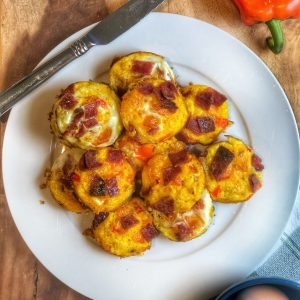 mini sweet potato breakfast quiches on a white plate with a knife on the side